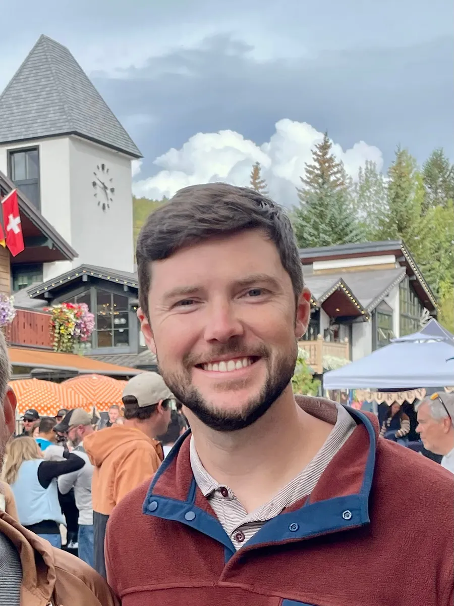Parker Poage smiling in Vail Village on an overcast afternoon.
